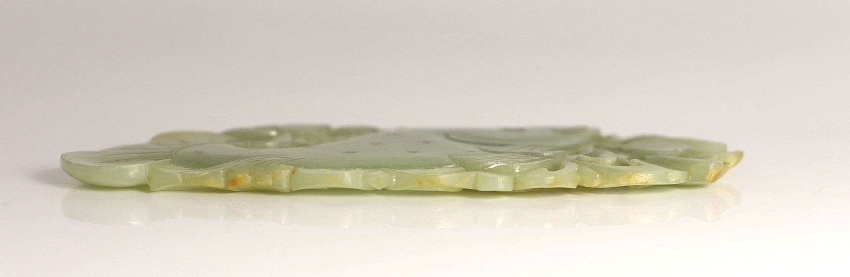 A Chinese pale celadon jade 'fish' plaque, 18th/19th century, 16.7cm long, 8.5cm high, later wood stand for use as a table screen